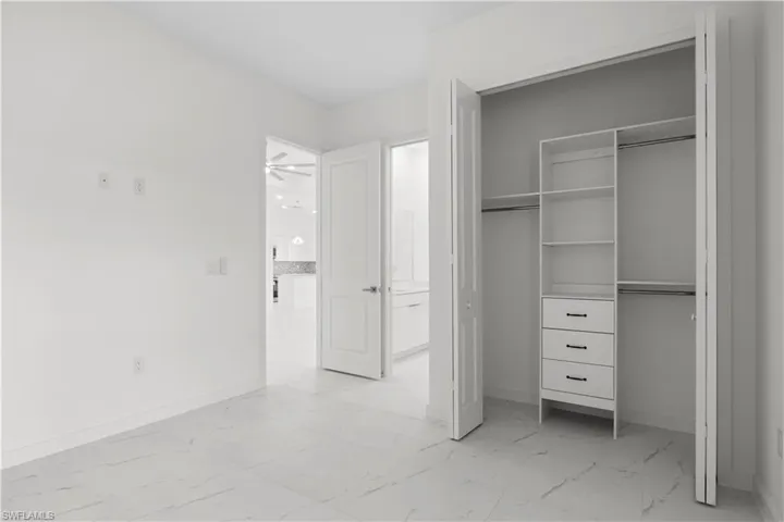Unfurnished bedroom featuring light marble finish flooring and a closet