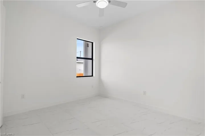 Unfurnished room featuring baseboards and light marble finish floors