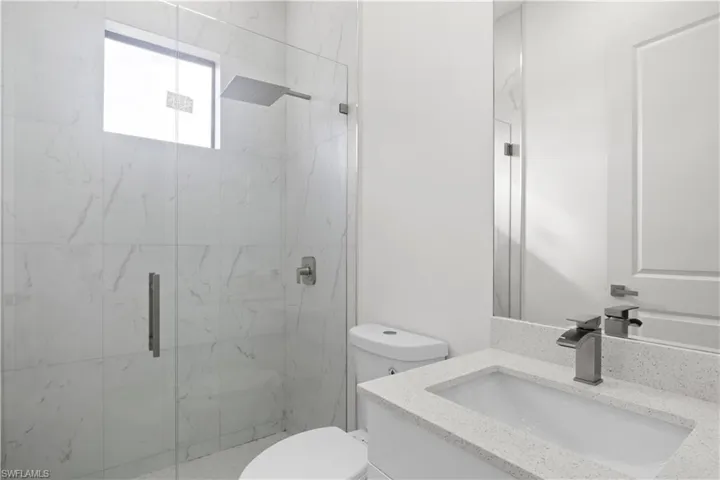 Full bath with vanity and a marble finish shower