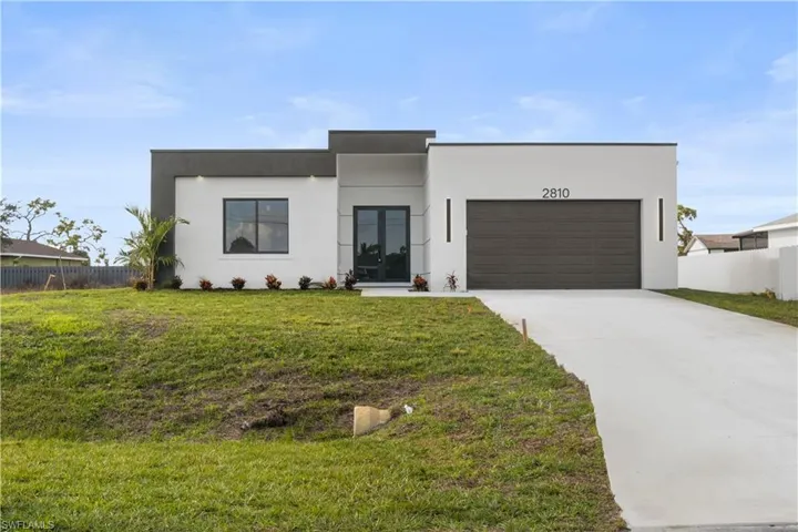 Contemporary home featuring driveway, stucco siding, and an attached garage