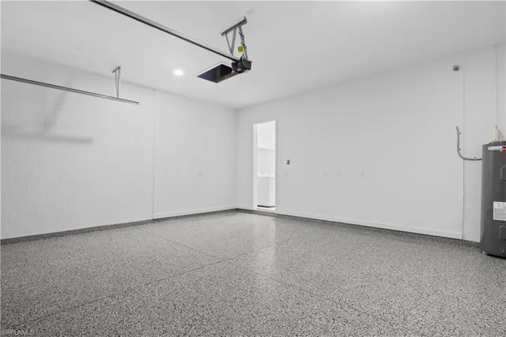 Garage with electric water heater and baseboards