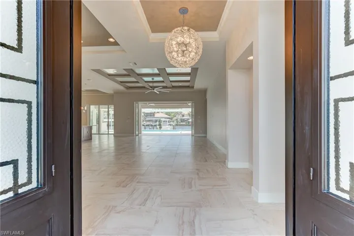 Entryway with a chandelier, coffered ceiling, ornamental molding, beamed ceiling, and recessed lighting