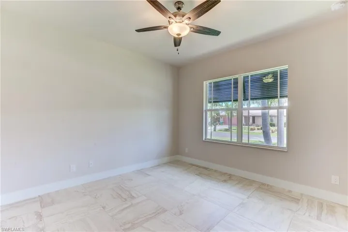 Unfurnished room featuring baseboards and a ceiling fan