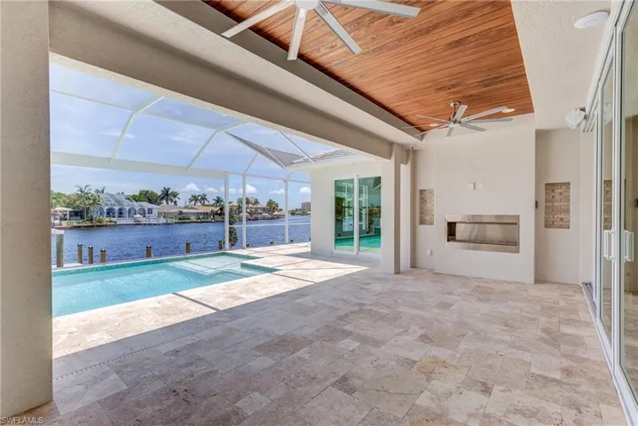 Swimming pool with a sunroom, a patio area, a lanai, and a water view