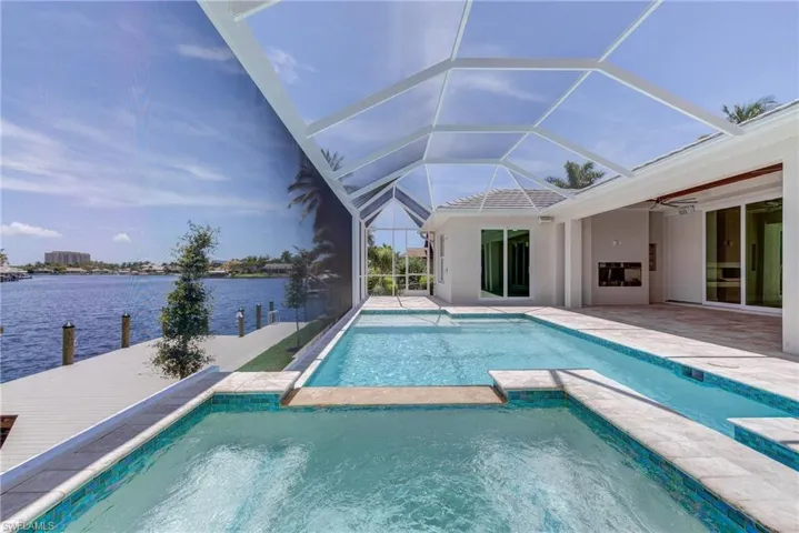View of swimming pool with a sunroom, a patio, glass enclosure, and a pool with connected hot tub