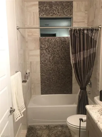 Full bathroom featuring shower / bath combo with shower curtain and vanity