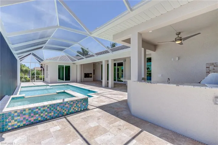 View of pool with a sunroom, a patio, glass enclosure, and a pool with connected hot tub