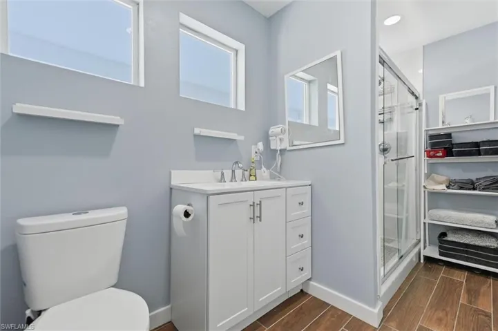Full bathroom with a stall shower, wood tiled floors, vanity, and recessed lighting