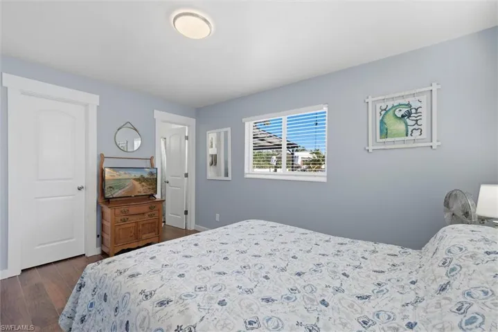 Bedroom with dark wood-style flooring and baseboards
