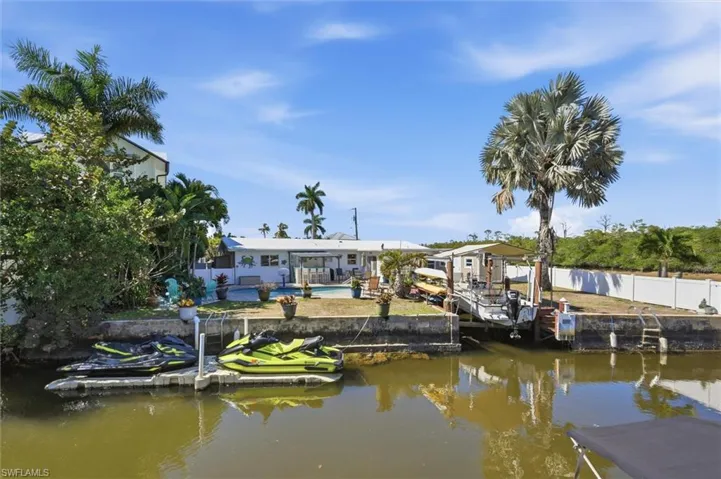 Dock with a water view, an outdoor pool, and boat lift