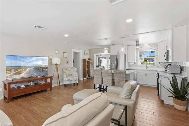 Living room with light wood-style flooring and recessed lighting