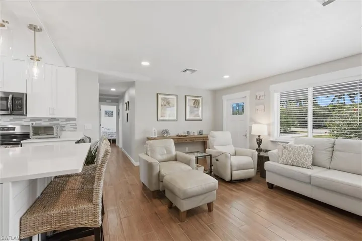 Living room with light wood finished floors and recessed lighting