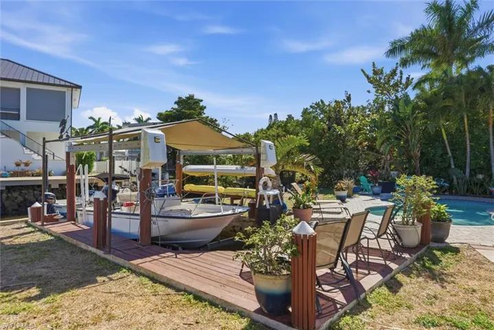 Wooden terrace with an outdoor pool and a boat dock