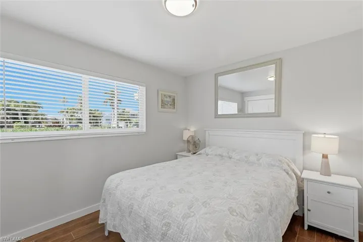 Bedroom with dark wood-type flooring and multiple windows