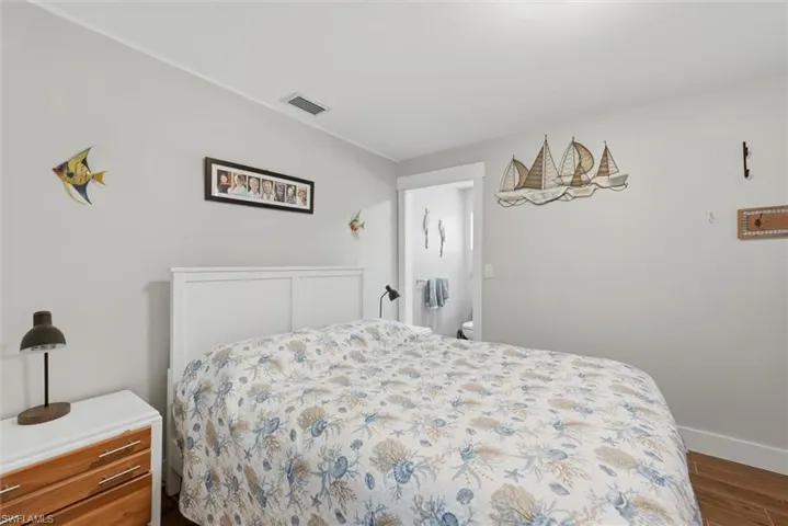Bedroom with dark wood finished floors and baseboards