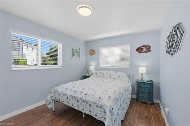 Bedroom with wood tiled floors and baseboards