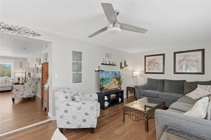 Living area with wood finished floors and ceiling fan