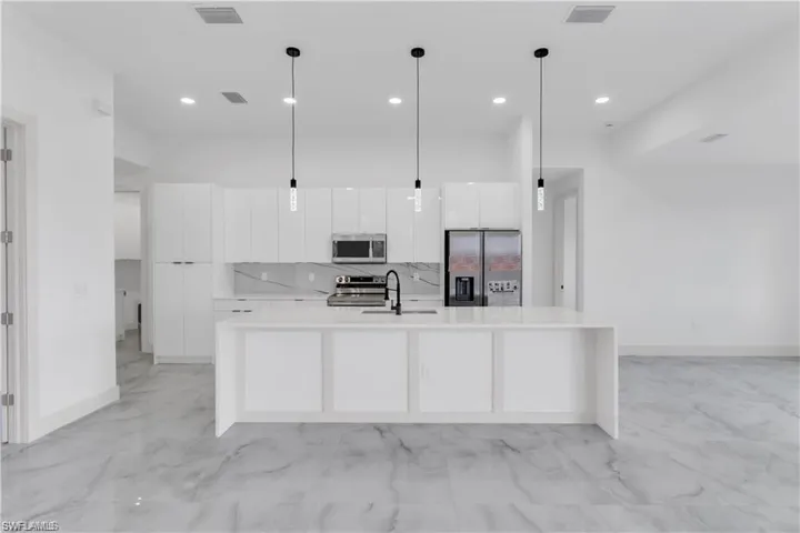 Kitchen featuring visible vents, white cabinets, modern cabinets, stainless steel appliances, and marble finish floor