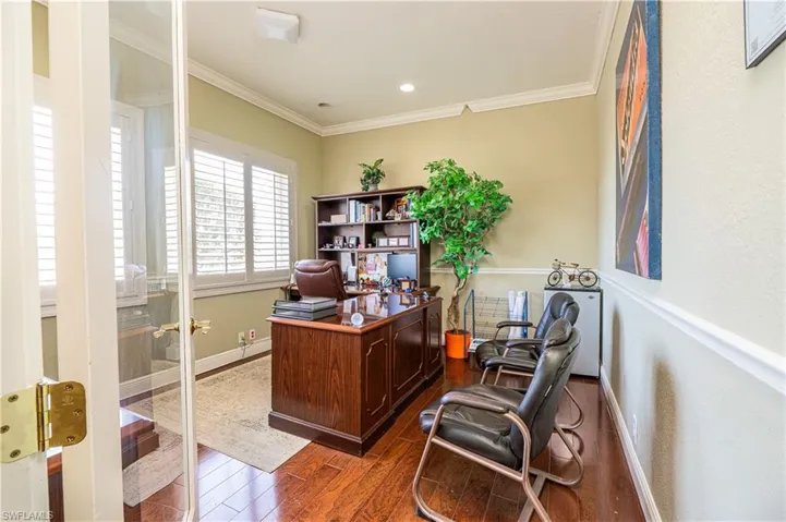 Office area with dark wood-style flooring, baseboards, recessed lighting, and crown molding