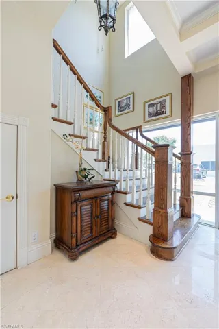 Stairs featuring ornamental molding, a high ceiling, a chandelier, and baseboards