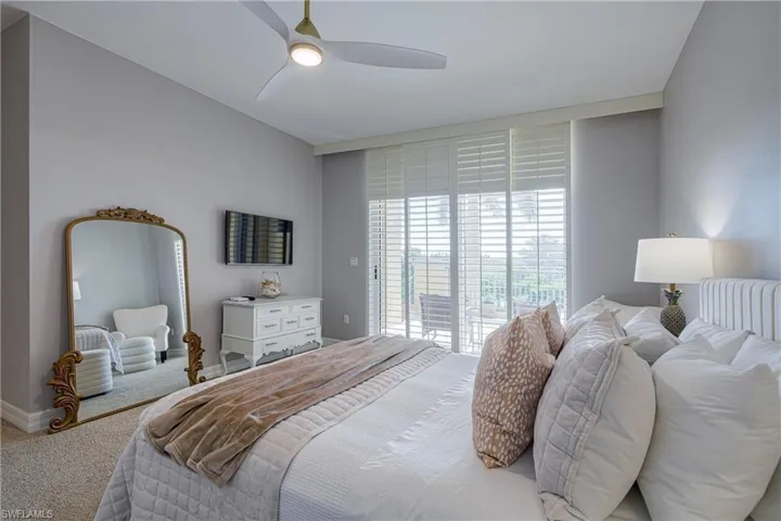 Carpeted room featuring a ceiling fan with integrated lighting, a sliding glass door with horizontal blinds opening to an outdoor area, and light gray wall paint