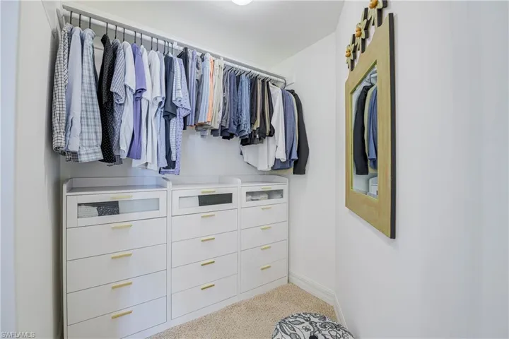 Built-in custom closet system featuring multiple hanging rods and integrated drawer storage