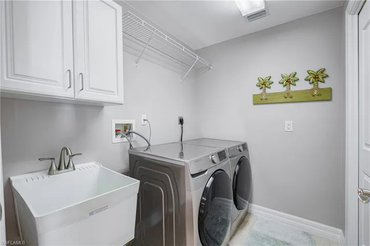 Dedicated utility room featuring white cabinetry, a utility sink with a brushed nickel faucet, and overhead wire shelving