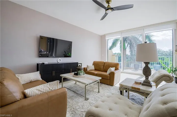 Bright living area with full-height sliding glass doors opening to an outdoor patio
