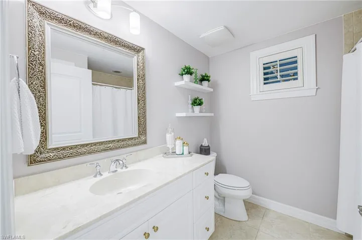 Bathroom featuring a vanity with a light-colored countertop, an undermount sink, and polished chrome fixtures