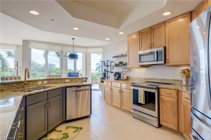 Kitchen featuring a dual-tone cabinetry design, granite countertops, and recessed lighting
