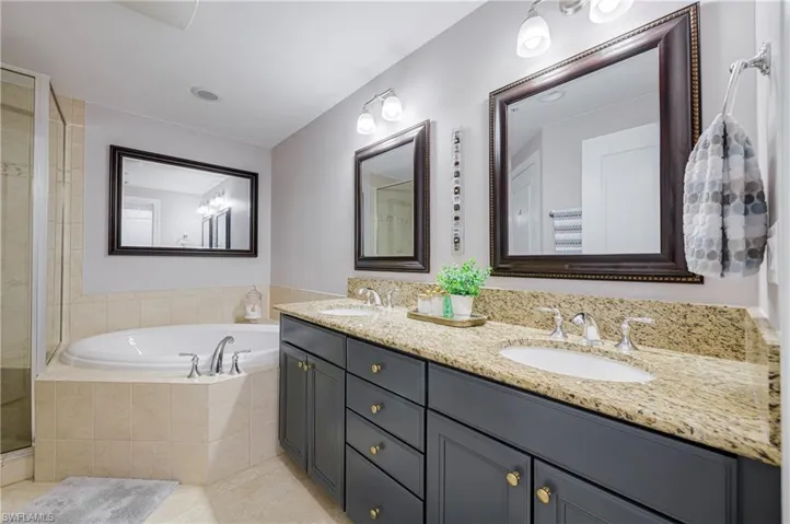 Dual vanity with granite countertops, undermount sinks, and dark cabinetry