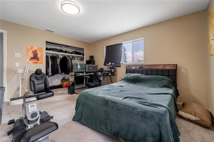 Carpeted bedroom featuring a closet and baseboards
