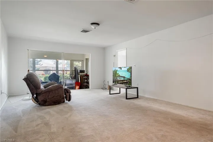 Living area featuring carpet floors and baseboards