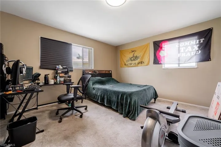 Bedroom with carpet flooring and a desk