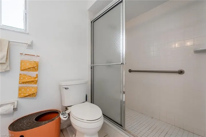 Full bath with a shower stall and tile patterned flooring