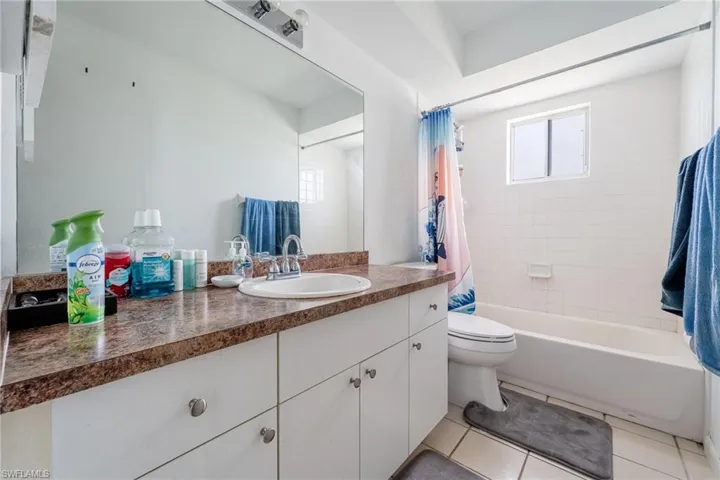 Bathroom with shower / bath combo, vanity, and light tile patterned floors