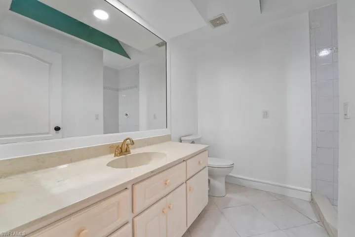 Vanity with an integrated sink, gold-tone faucet, and stone-finish countertop
