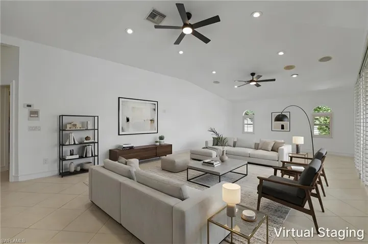 Vaulted ceiling with recessed lighting and ceiling fans.