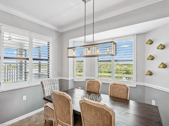 Dining space with hardwood / wood-style flooring and crown molding