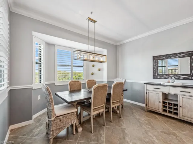 Dining space with ornamental molding and light tile patterned floors