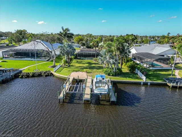 Dock area featuring a water view, a yard, and a lanai