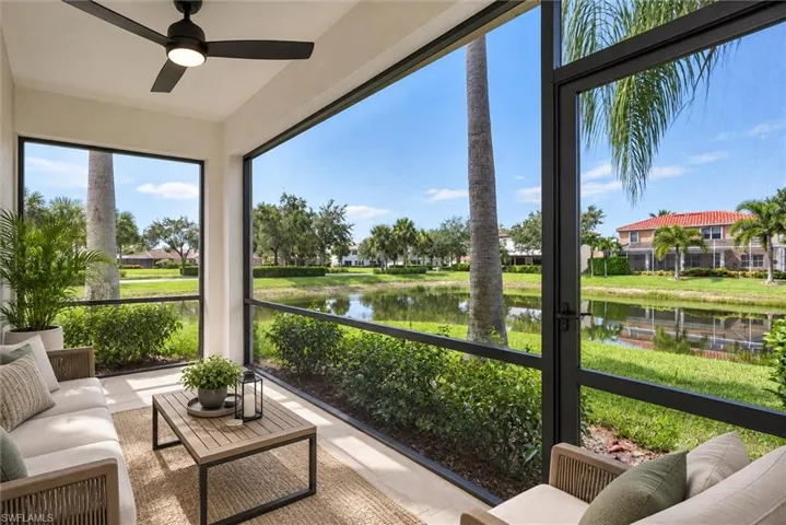 Screened outdoor living area with a ceiling fan, offering broad water and landscape scenery