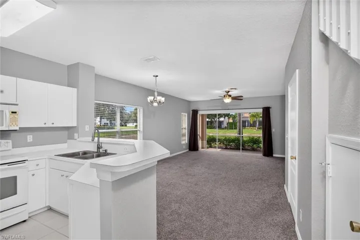 Kitchen with white cabinetry, white countertops, and stainless steel sink