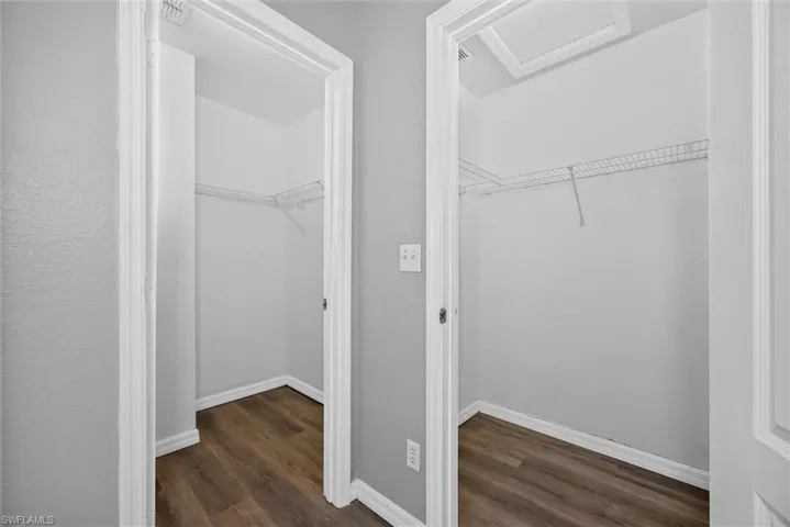 Two closets featuring wire shelving and wood-finish flooring