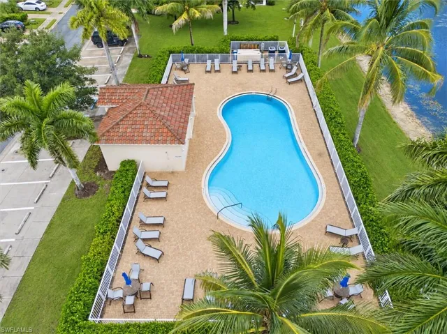 Freeform swimming pool with integrated steps, surrounded by a paved deck