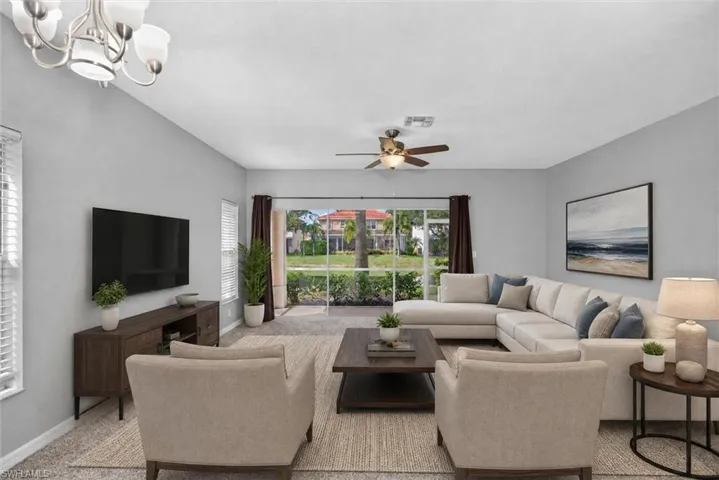 Spacious living area featuring light gray walls, a ceiling fan, and large sliding glass doors