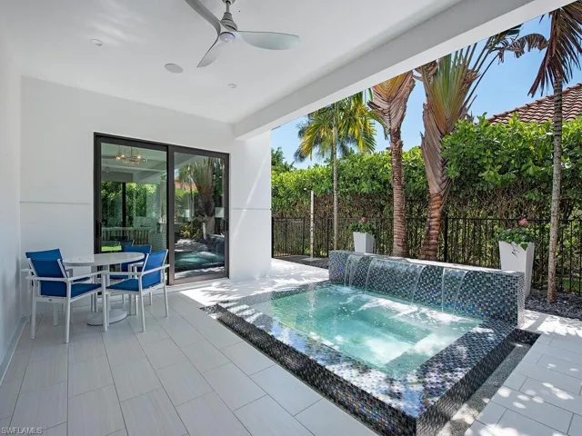 View of pool with ceiling fan, a jacuzzi, a patio, and pool water feature