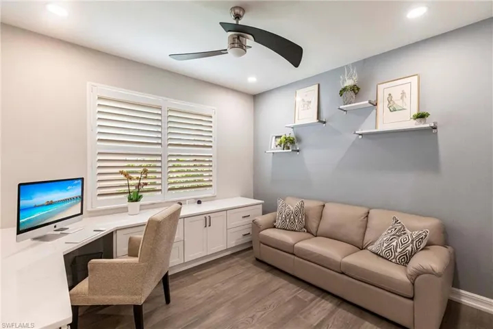 Office space with a ceiling fan, wood finished floors, recessed lighting, and built in study area