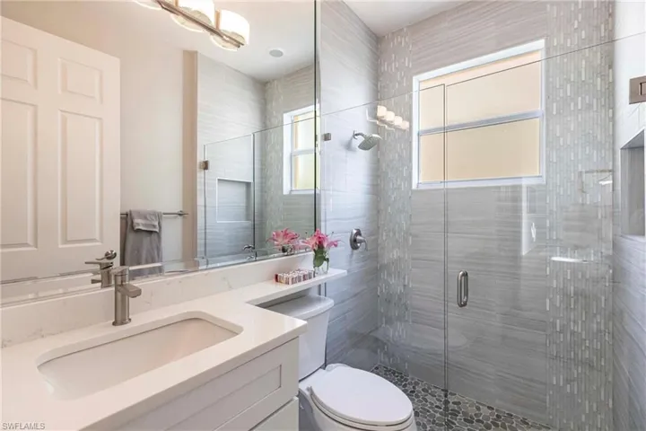 Bathroom with healthy amount of natural light, a stall shower, and vanity