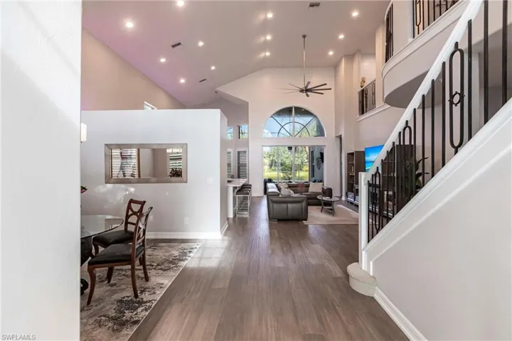 Entrance foyer featuring a towering ceiling, wood finished floors, recessed lighting, stairs, and a ceiling fan